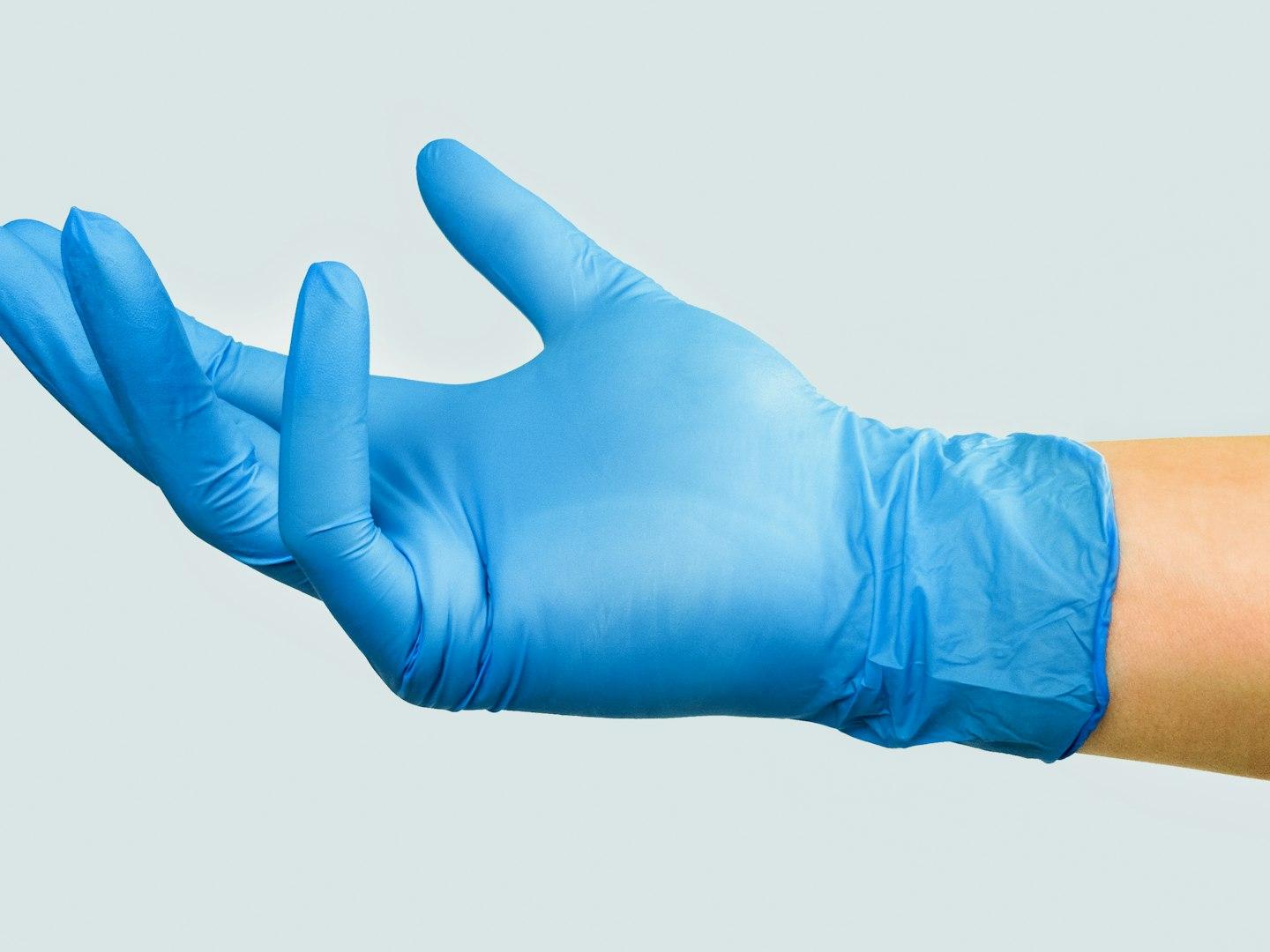 person in blue gloves with white background